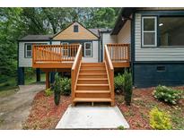 Charming home exterior featuring wooden stairs and deck, perfect for outdoor entertaining at 243 Howell Ter, Atlanta, GA 30331