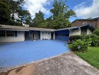 Charming single-story home with blue accents, a unique driveway, and a well-maintained front yard at 2323 Valleyside Dr, Decatur, GA 30032