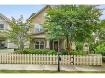 Charming two-story home with a welcoming front yard, lush landscaping, and a classic white picket fence at 1184 Medlin Se St, Smyrna, GA 30080