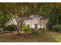 Elegant home featuring manicured landscaping and a charming facade with lush surrounding trees at 8255 Habersham Waters Rd, Atlanta, GA 30350