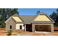 Charming single-story home featuring stone accents, a welcoming front porch, and an attached two-car garage at 490 Charleston Pl, Villa Rica, GA 30180