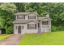 Charming two-story home features a front porch, manicured lawn, and welcoming curb appeal at 6114 Leverett Dr, Lithonia, GA 30038