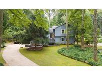 Charming home with light blue siding, stone accents, and a welcoming front yard with mature trees at 1880 Doefield St, Canton, GA 30115