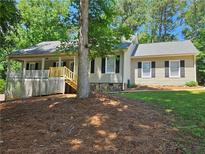 Charming home with a lovely front porch, complemented by mature trees and a well-maintained lawn at 105 Old Hickory Pointe, Mcdonough, GA 30252