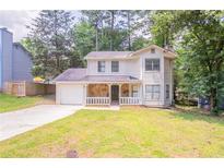 Charming two-story home featuring stone accents, a covered front porch, and a single-car garage at 5292 Mountain Village Ct, Stone Mountain, GA 30083