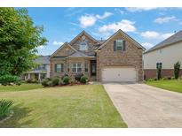 Charming brick two-story home with a well-manicured lawn and a two-car garage at 6370 Stillwood Ln, Cumming, GA 30041