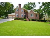 Charming two-story brick home featuring a well-manicured lawn and a three-car garage at 830 Cramac Dr, Lawrenceville, GA 30046