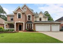 Charming brick two-story home with well-manicured lawn, inviting curb appeal, and a three car garage at 1055 Beacon Hill Xing, Alpharetta, GA 30005