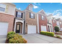 Charming townhome exterior featuring a well-maintained lawn and attached one-car garage at 2457 Birkhall Way # 2457, Lawrenceville, GA 30043