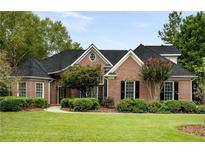Traditional brick home with a well-manicured lawn and mature landscaping at 3753 Honey Pot Ne Way, Marietta, GA 30066