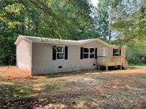 Charming single-story home featuring neutral siding, black shutters, and a welcoming front porch at 921 Marshall Fuller Rd, Dallas, GA 30157