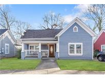 Charming blue cottage featuring a cozy front porch and well-manicured lawn at 1087 Longley Nw Ave, Atlanta, GA 30318