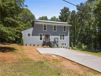 Charming two-story home with a modern metal roof and a freshly poured concrete driveway at 2158 Huckleberry Ln, Lithia Springs, GA 30122
