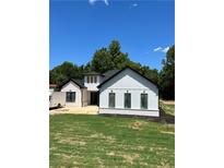 Modern farmhouse with white siding, black trim, and a well-manicured lawn, all under a clear blue sky at 520 Rockbridge Rd, Lilburn, GA 30047