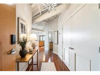 Hallway featuring hardwood floors, stylish decor, and access to various rooms including the living area and bathroom at 878 Peachtree Ne St # 704, Atlanta, GA 30309