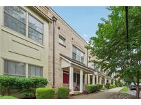 Charming brick townhouse with covered porch, manicured bushes, and lush green tree at 190 Marion Ne Pl, Atlanta, GA 30307