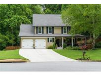 Charming two-story home with a well-manicured lawn, two-car garage, and inviting front porch at 2263 Hill Creek Way, Marietta, GA 30062