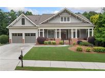 Charming single-Gathering home featuring a large front porch, two-car garage, and beautifully landscaped front yard at 3157 Perimeter Cir, Buford, GA 30519