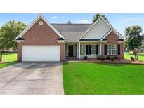 Charming single-story home with brick and siding, a manicured lawn, and an attached two-car garage at 16 Kentucky Ne Walk, Cartersville, GA 30121