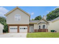 Charming two-story home showcasing a two-car garage, brick accents and siding, complete with a well-maintained lawn at 4400 Old Allgood Cir, Stone Mountain, GA 30083