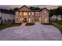 Striking brick exterior with grand entrance, circular driveway, and attached two-car garage at 157 Shadburn Ferry Rd, Buford, GA 30518