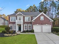 Beautiful brick two-story home with a two-car garage, manicured lawn, and lush landscaping at 3224 Wolf Club Sw Ln, Atlanta, GA 30349