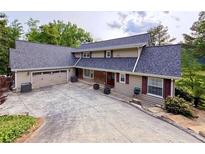 Inviting home featuring a large driveway, attached two-car garage, and meticulously maintained landscaping at 8710 Mount Rushmore Dr, Johns Creek, GA 30022