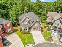 Beautiful craftsman home featuring well-manicured lawn, three-car garage, and mature trees in a desirable neighborhood at 931 Hidden Falls Se Ln, Smyrna, GA 30082
