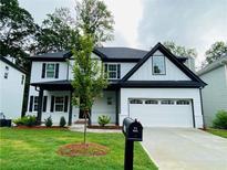 Beautiful two-story home featuring modern white siding, black trim, and a well-manicured lawn at 1540 Ox Bridge Ct, Lawrenceville, GA 30043