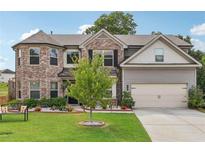 Charming two-story home with a brick facade, well-manicured lawn, and attached two-car garage at 3126 Cove View Ct, Dacula, GA 30019