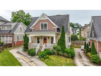Charming two-story home featuring a covered front porch, manicured landscaping, and craftsman-style architecture at 1122 Parkview Pl, Smyrna, GA 30080
