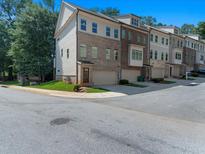 A multi-story townhome with brick and siding, complemented by a well-maintained front yard at 1110 Bakary Ct, Decatur, GA 30032