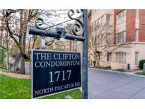 View of The Clifton Condominium signage at 1717 North Decatur Rd, with manicured landscaping and building in background at 1717 N Decatur Ne Rd # 117, Atlanta, GA 30307