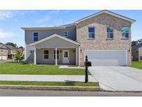 Charming two-story home features a combination of brick and siding, a two-car garage, and a well-manicured lawn at 3634 Oakleaf Pass, Fairburn, GA 30213
