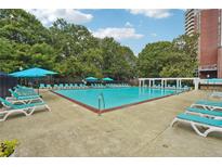 Resort style community pool with lounge chairs and umbrellas for relaxing by the water at 377 Ralph Mcgill Ne Blvd # C, Atlanta, GA 30312