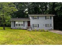 Charming home featuring a well-manicured lawn, gray brick facade and neatly trimmed shrubbery at 2436 Glenrock Dr, Decatur, GA 30032