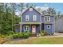 Charming two-story home featuring a pink door and inviting front porch with seating at 1916 River Birch Ln, Atlanta, GA 30316
