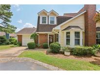 Charming home featuring a brick facade, well-manicured lawn and two-car garage on a sunny day at 107 Mary Gay Ct, Decatur, GA 30030
