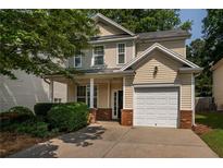 Charming two-story home with a well-maintained lawn, attached garage, and inviting front porch at 208 Oconee Way, Canton, GA 30114