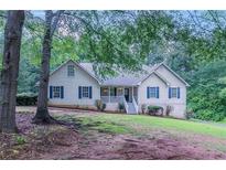 Charming one-story home with a well-manicured lawn and inviting front porch surrounded by mature trees at 260 Pleasant Grove Cir, Mcdonough, GA 30252