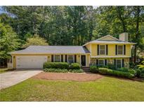 Charming two-story home with a well-manicured front yard, stone accents, and attached two-car garage at 9685 Cone Ct, Roswell, GA 30075
