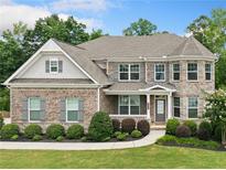 Charming two-story brick home features manicured landscaping and a welcoming front porch at 127 Sanctuary Ave, Woodstock, GA 30188