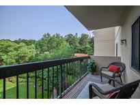Relax on this charming balcony with comfortable seating and serene views of lush greenery at 1800 Clairmont Lk # 413, Decatur, GA 30033