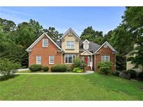 Charming two-story brick home featuring well-maintained landscaping and a welcoming front entrance at 1920 Lee Patrick Dr, Dacula, GA 30019
