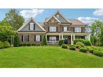 Beautiful brick home with a well-manicured lawn and covered front porch at 107 Equest Dr, Canton, GA 30115