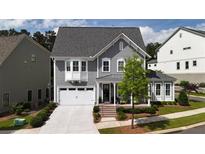 Charming two-story home features a manicured lawn, gray siding and a white two car garage at 258 Dawson Dr, Woodstock, GA 30188