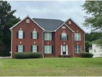 Charming two-story red brick home with a well-manicured front lawn and classic architectural details at 10175 Hemlock Way, Jonesboro, GA 30238