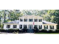 Traditional two-story home with black shutters and American flag on large front porch with pillars at 212 Teepee Trl, Whitesburg, GA 30185