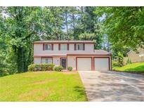 Charming two-story home featuring a well-manicured lawn, mature trees, and an attached two-car garage at 5092 Stone Trce, Stone Mountain, GA 30083