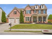 Charming two-story brick home with a well-manicured lawn and a two-car garage at 5310 Chestnut Dr, Cumming, GA 30040